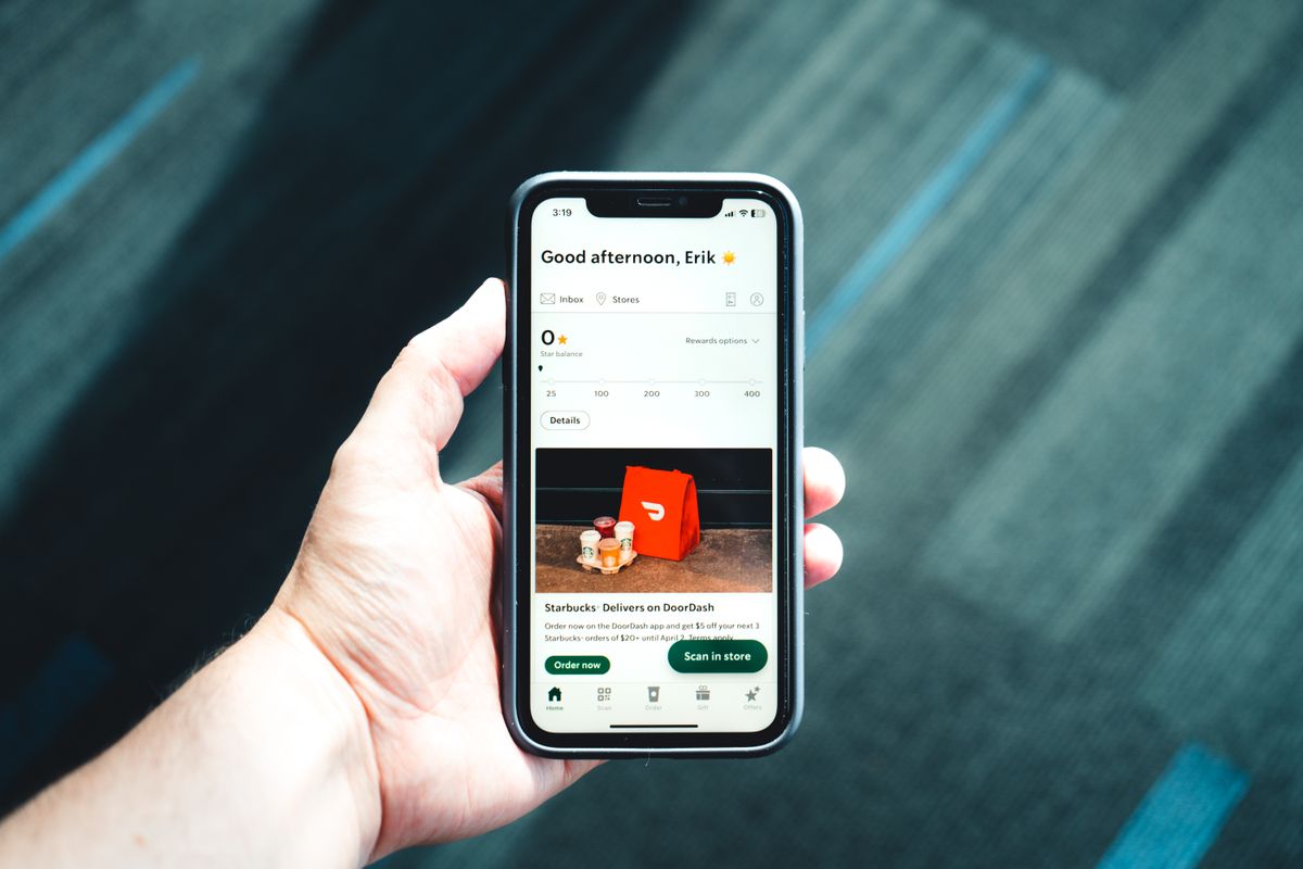 Hand holding a phone showing a custom app interface